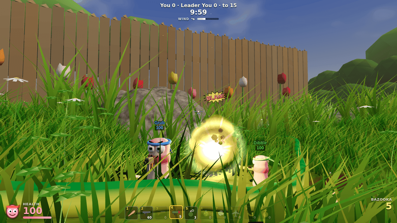 First-person view through towering grass blades as a bazooka blast lands between two worms in front of a wooden fence and tulips.